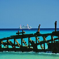 Segelbootwrack mit Kreuzfahrtschiff uSurfern