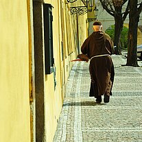 Kapuzinermönch auf dem Weg unter den Laternen